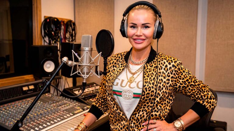 Зайферт Злата в наушниках, леопардовой куртке и футболке Gucci улыбается в студии звукозаписи у микшерного пульта.